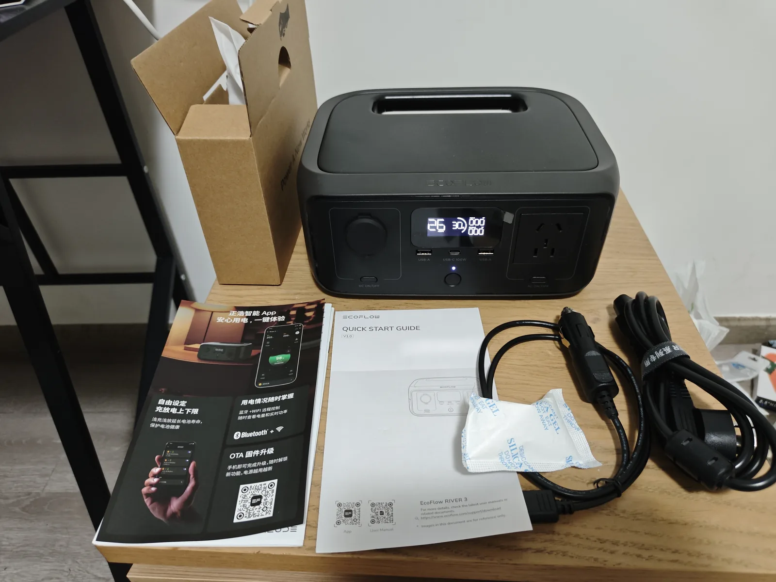 EcoFlow RIVER 3 unboxing showing the power station, AC charging cable, car charge cable and printed quick-start guide